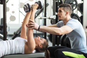Fitness instructor exercising with his client at the gym_80960258-1600x1600